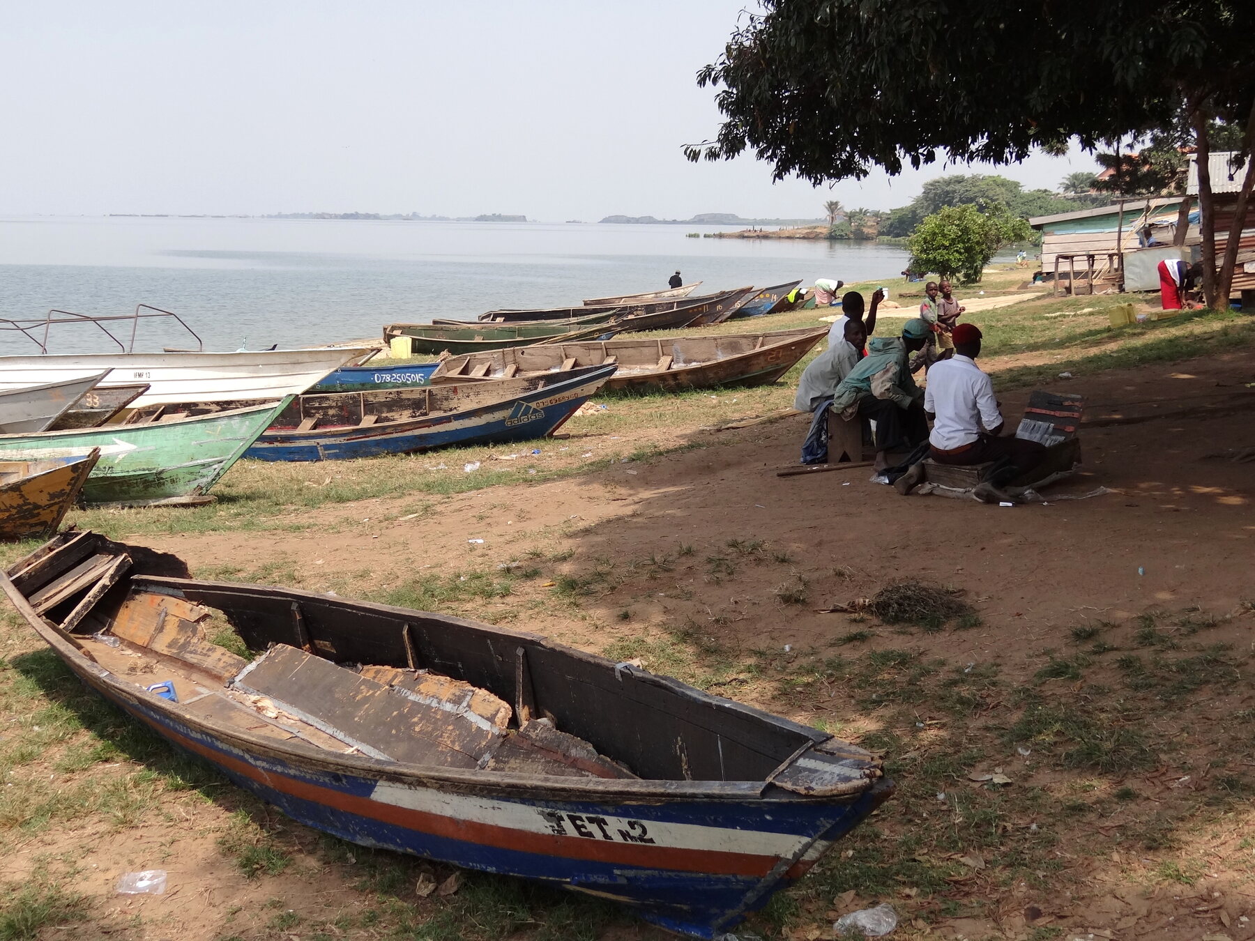 Barcas de pesca y habitantes de una aldea a orillas del lago Victoria en Entebbe