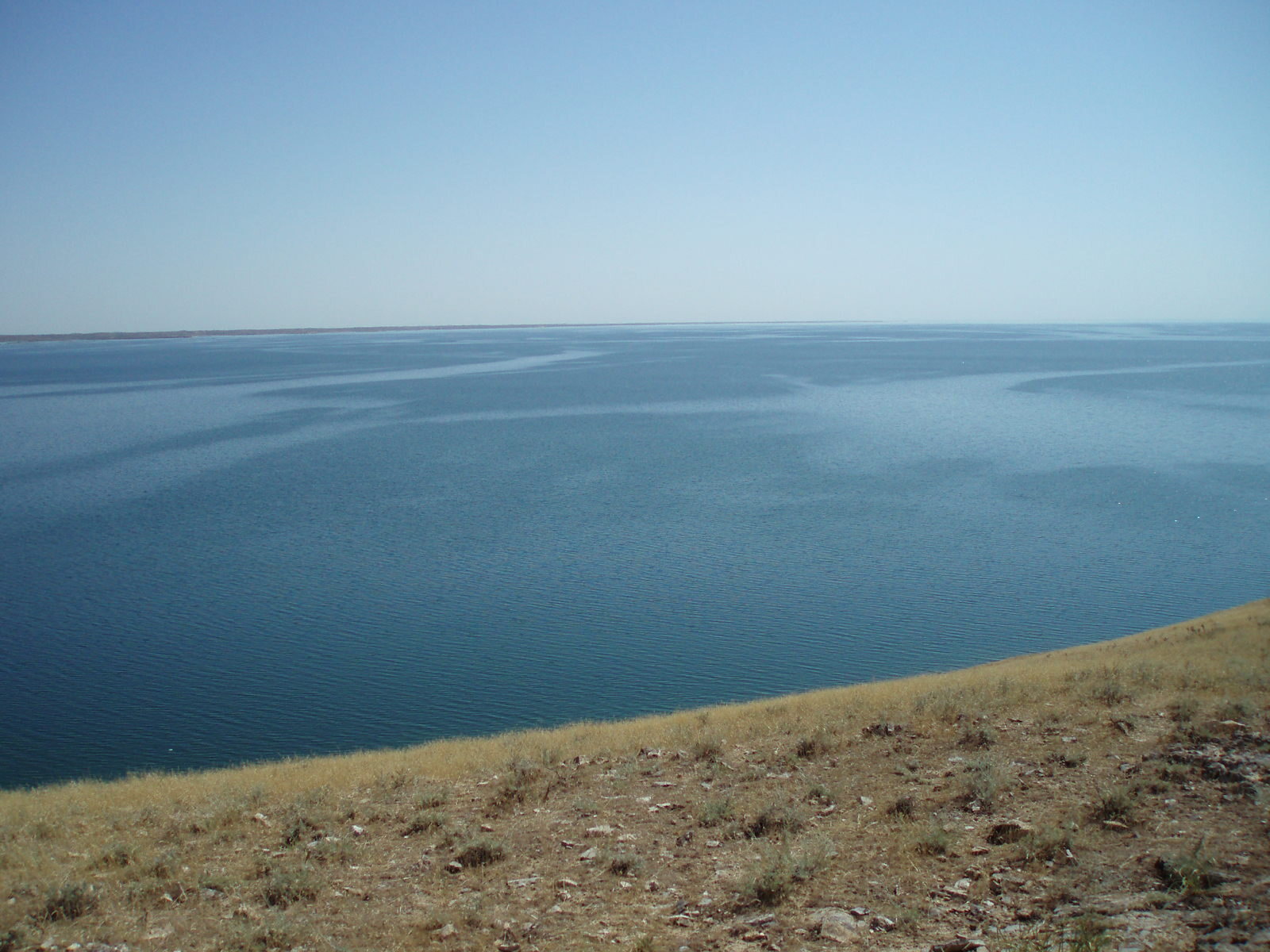 Lago Aydarkul de aguas azules junto a una costa desértica