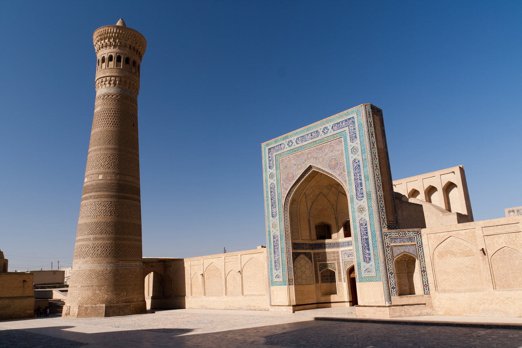 Patio de Poi Kalyan con arquerías, cúpula azul y el minarete Kalyan
