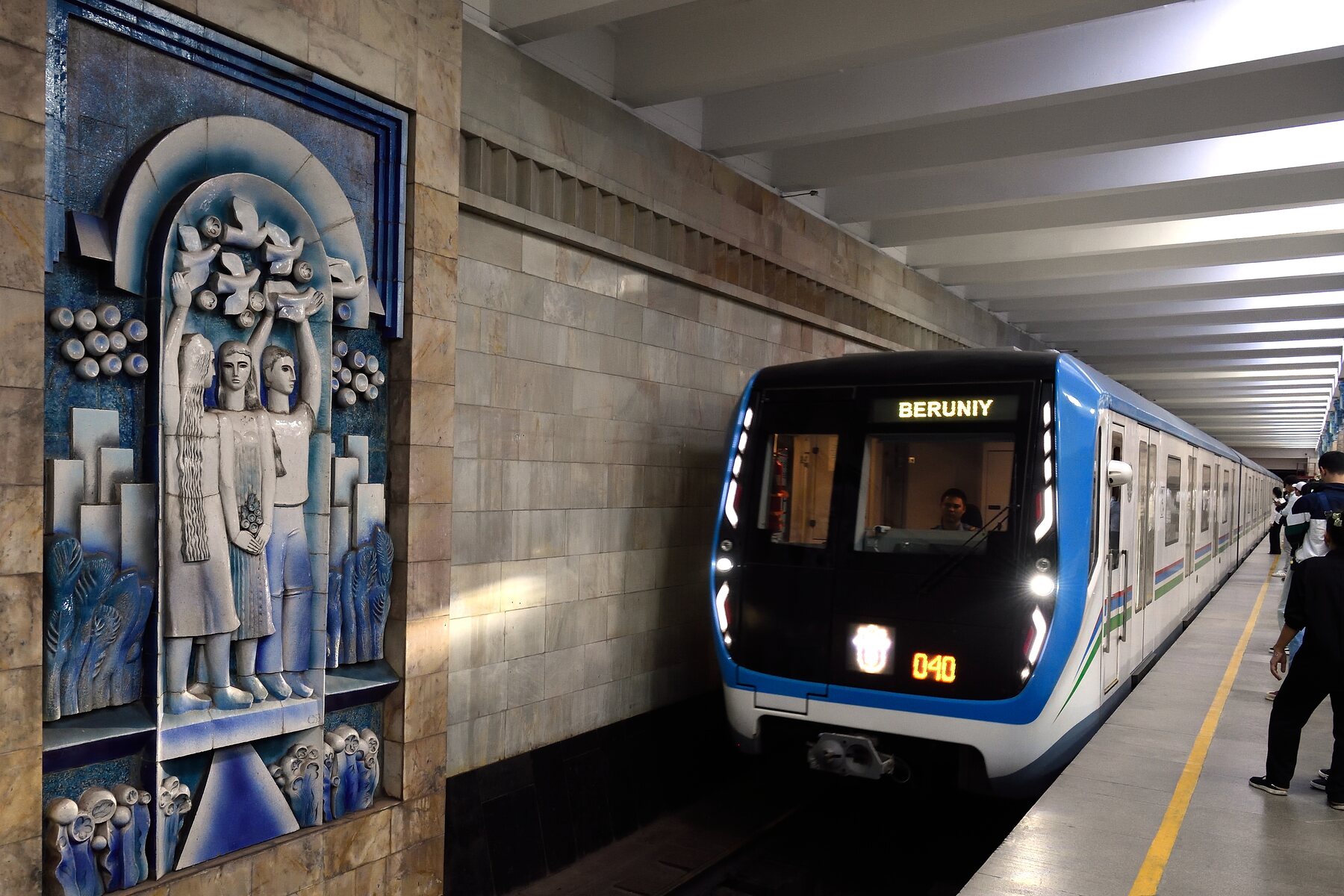 Andén de la estación Toshkent del metro con columnas blancas y lámparas ornamentales